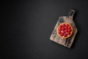 Delicious fresh sweet round tart with ripe raspberries and cream photo