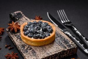 Delicious fresh sweet round tart with ripe blueberries and cream photo