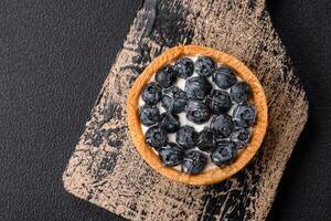 Delicious fresh sweet round tart with ripe blueberries and cream photo