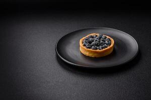 Delicious fresh sweet round tart with ripe blueberries and cream photo