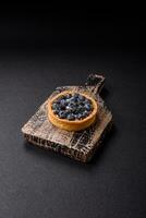 Delicious fresh sweet round tart with ripe blueberries and cream photo