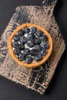 Delicious fresh sweet round tart with ripe blueberries and cream photo