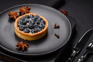 Delicious fresh sweet round tart with ripe blueberries and cream photo