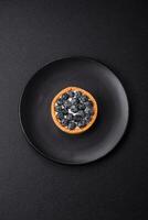 Delicious fresh sweet round tart with ripe blueberries and cream photo