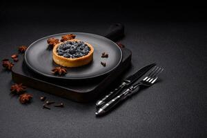 Delicious fresh sweet round tart with ripe blueberries and cream photo