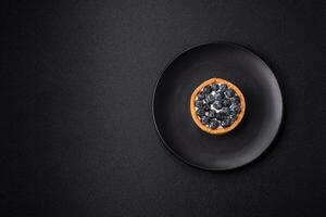 Delicious fresh sweet round tart with ripe blueberries and cream photo