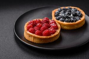 Delicious fresh sweet round tart with ripe raspberries and cream photo