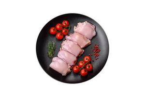 Fresh raw chicken thigh fillets with salt, spices and herbs photo