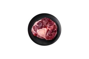 Fresh beef ossobuco steak with salt, spices and herbs photo