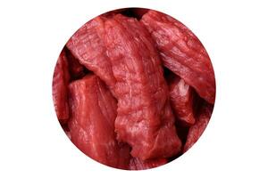 Raw organic meat beef or lamb cut into slices with salt, spices and herbs photo