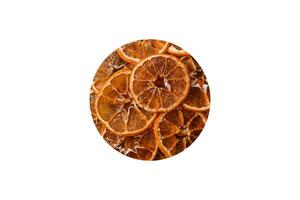 Dried round slices of tangerine, orange or lemon on a dark concrete background photo