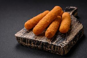 Delicious crispy cheese sticks with mozzarella, salt and spices, breaded and fried in oil photo