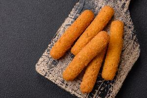 Delicious crispy cheese sticks with mozzarella, salt and spices, breaded and fried in oil photo