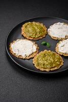 Round snacks with crispy chips or crackers with cream cheese and pesto photo