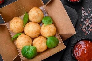 Delicious round balls of mozzarella and parmesan cheese with salt and breaded spices photo