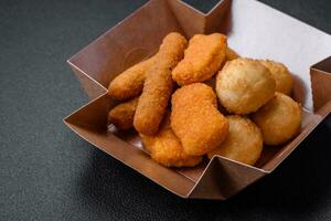 Delicious nuggets, sticks and balls of mozzarella and parmesan cheese with salt and spices photo