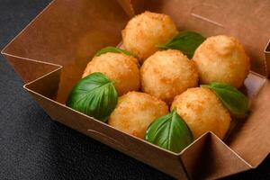 Delicious round balls of mozzarella and parmesan cheese with salt and breaded spices photo