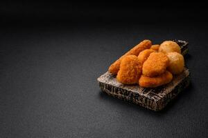 Delicious nuggets, sticks and balls of mozzarella and parmesan cheese with salt and spices photo