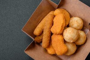 Delicious nuggets, sticks and balls of mozzarella and parmesan cheese with salt and spices photo