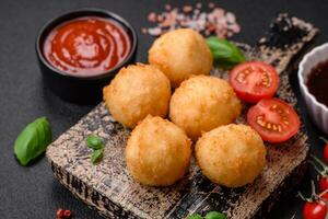 Delicious round balls of mozzarella and parmesan cheese with salt and breaded spices photo