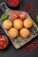 Delicious round balls of mozzarella and parmesan cheese with salt and breaded spices photo