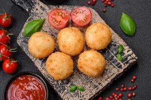 Delicious round balls of mozzarella and parmesan cheese with salt and breaded spices photo