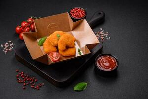 deliciosos nuggets de pollo crujientes y frescos sobre un fondo de hormigón oscuro foto