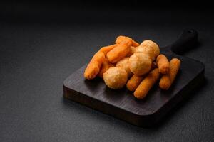 Delicious nuggets, sticks and balls of mozzarella and parmesan cheese with salt and spices photo