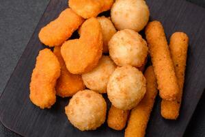 Delicious nuggets, sticks and balls of mozzarella and parmesan cheese with salt and spices photo