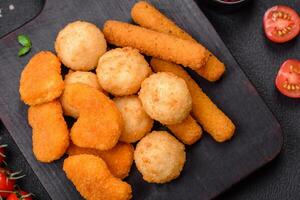 Delicious nuggets, sticks and balls of mozzarella and parmesan cheese with salt and spices photo