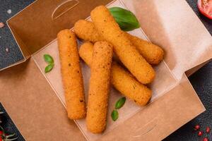 Delicious crispy cheese sticks with mozzarella, salt and spices, breaded and fried in oil photo