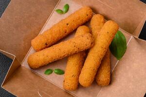 Delicious crispy cheese sticks with mozzarella, salt and spices, breaded and fried in oil photo