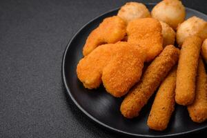 Delicious nuggets, sticks and balls of mozzarella and parmesan cheese with salt and spices photo