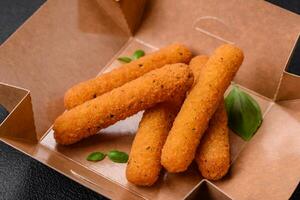 Delicious crispy cheese sticks with mozzarella, salt and spices, breaded and fried in oil photo