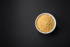 Raw whole grain orzo pasta as an ingredient for a delicious dish photo