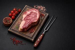 Fresh juicy raw beef striploin steak with salt and spices photo