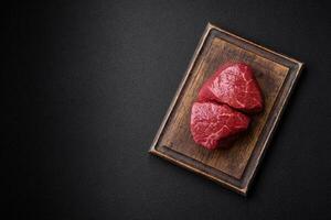 Fresh juicy raw beef medallions with salt and spices photo