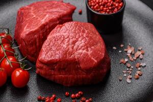 Fresh juicy raw beef medallions with salt and spices photo