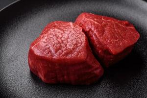 Fresh juicy raw beef medallions with salt and spices photo