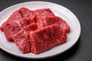 Fresh juicy raw beef slices with salt and spices photo