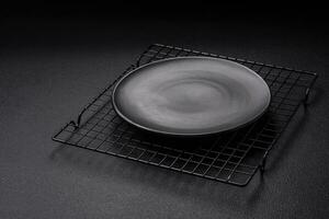 Empty ceramic round plate on dark textured concrete background photo