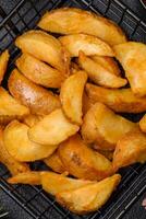 Delicious crispy fried potato wedges with salt, spices and herbs photo