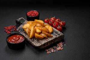 Delicious crispy fried potato wedges with salt, spices and herbs photo