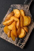 Delicious crispy fried potato wedges with salt, spices and herbs photo