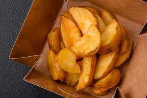 Delicious crispy fried potato wedges with salt, spices and herbs photo