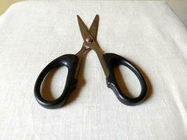 A pair of sharp scissors was wide open on table photo
