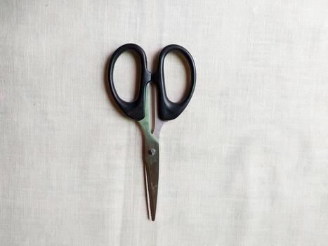A pair of sharp scissors was wide open on table photo