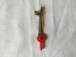 A steel compass with a lock screw and red top photo