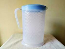 A plastic jug with blue cover is placed over photo