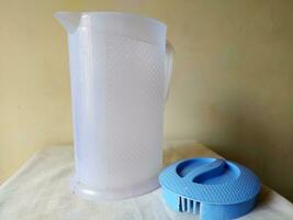 A plastic jug with blue cover is placed over photo